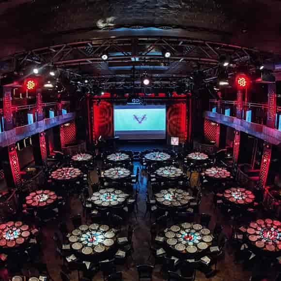Broadway Meeting Room gala dinner setup with red lighting and round tables for corporate events.