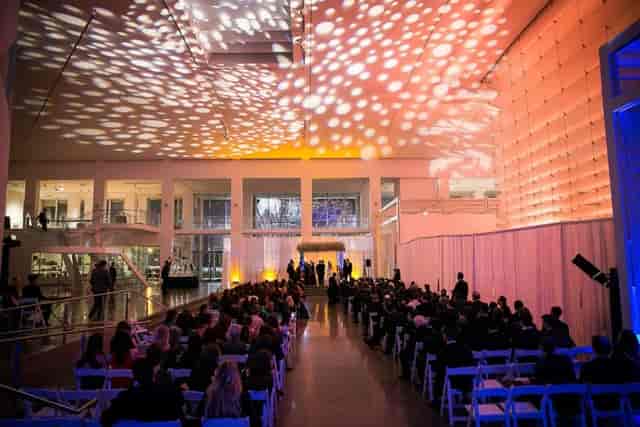 Gobo-lit Queens Museum Main Gallery: Elegant industrial wedding ceremony venue transformation.