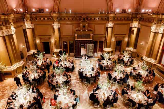 Elegant gala at The Gallery in Weylin featuring tiered lighting and tall floral centerpieces.