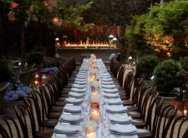 Intimate Bowery Garden alfresco dining with ambient candlelight for high-end outdoor event venues.