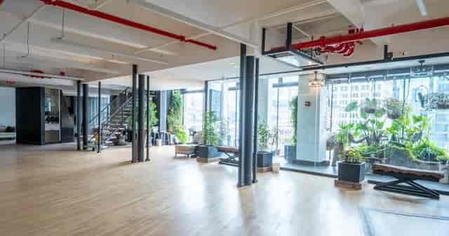 Industrial-chic event space with hardwood floors for corporate workshops and networking mixers.