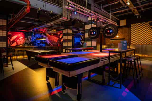 Modern event space at Roxy Lanes, Leeds with shuffleboard and vibrant decor.