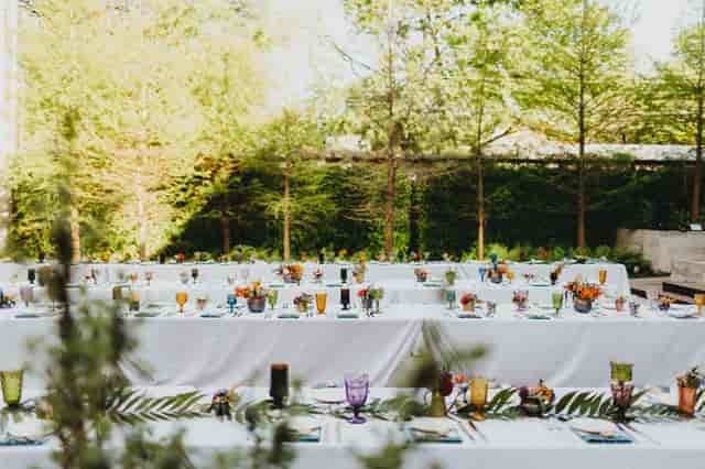 Outdoor garden banquet setup with white tables at South Congress Hotel for high-end social events.
