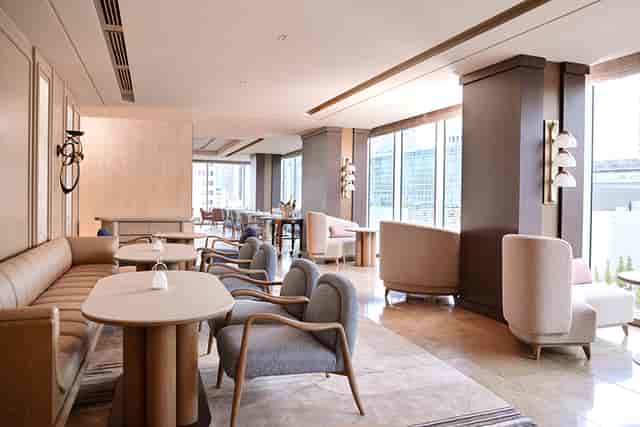 Corporate networking salon in SÉZANNE with bright booth seating for VIP hospitality events.