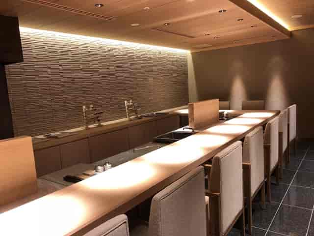 Teppanyaki restaurant with linear table and ambient lighting for VIP networking and strategy events.