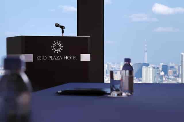 Kagari, Keio Plaza Hotel: Branded lectern against skyline for executive presentations.