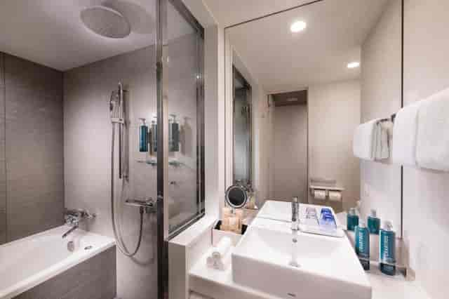 Modern hotel bathroom with shower-tub combo, ideal for corporate event room blocks.