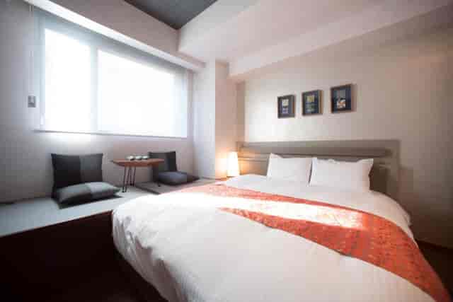 Modern Nishijin Suite hotel room with workspace for business travel and remote work.