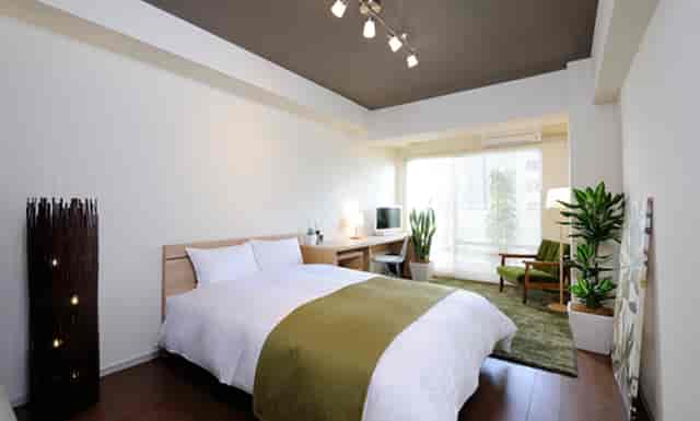 Modern Galerie T hotel room with queen bed and workspace for bleisure travel and remote work.