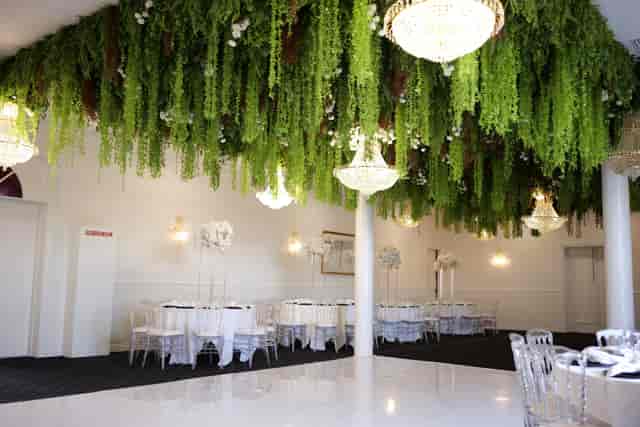 Greenery and chandelier ceiling installation at Fleur Weddings & Events gala or wedding venue.