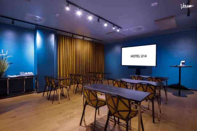 Modern breakout room with blue walls for workshops and professional business presentations.