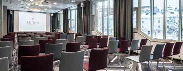 Theater-style meeting room with colorful chairs for corporate presentations and conferences.