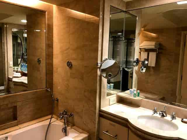 Luxury hotel bathroom with stone vanity at AYANA Midplaza Jakarta, corporate event accommodation.