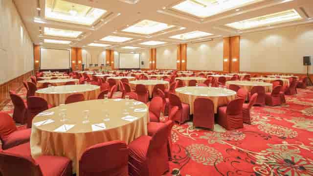 Grand Emerald Ballroom with round tables for corporate events or wedding gala dinners.