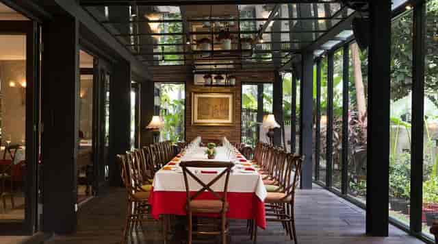 Private dining room in Patio Jakarta: upscale glass-walled boardroom for corporate event venue.