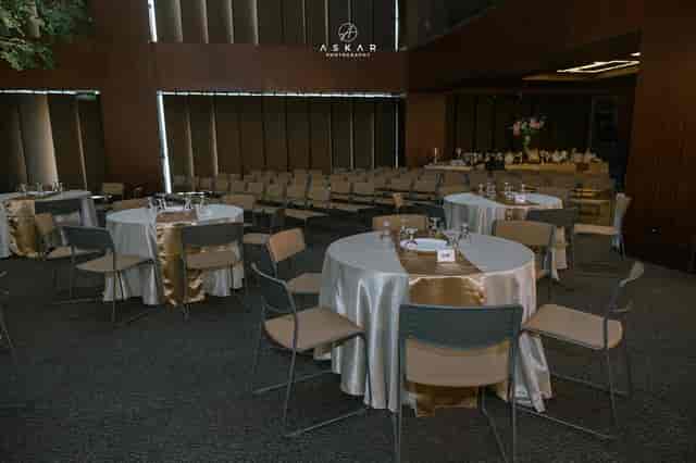Banquet-style Menara Kuningan ballroom with gold accents for corporate events and social gatherings.