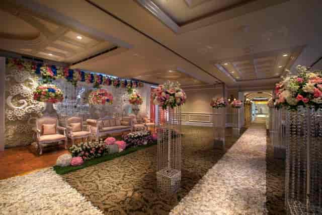 Elegant ballroom wedding venue with floral decor and crystal pillars, ideal for formal receptions.