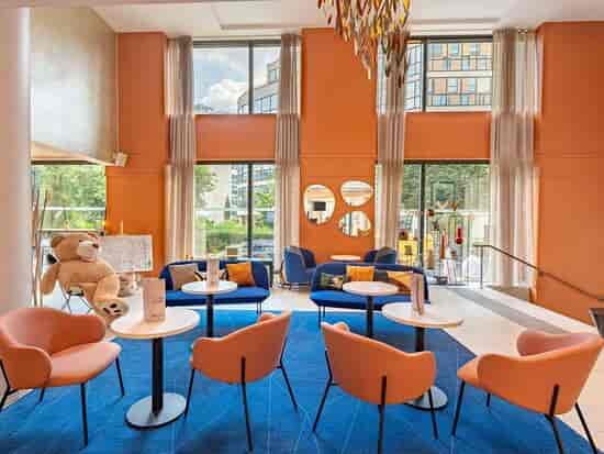 Modern hotel breakout space with vibrant lounge seating for corporate networking and events.