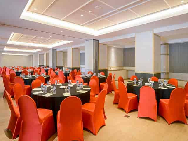 Banquet conference room with orange chairs for corporate events and business meetings.