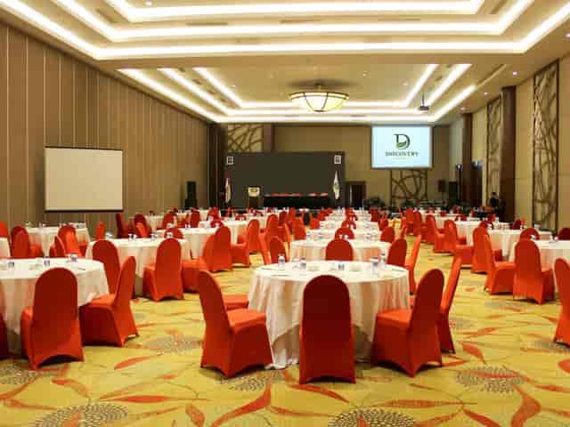 Banquet-style conference room with orange chairs for corporate events and networking.