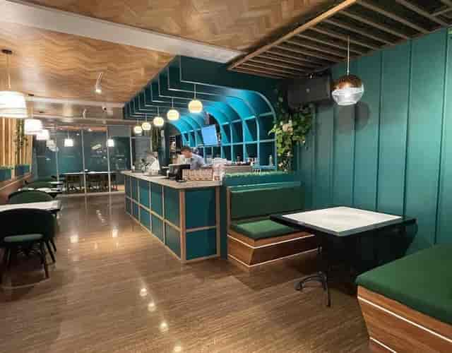 Modern teal-and-wood cafe for networking mixers and corporate breakout sessions in Jakarta.