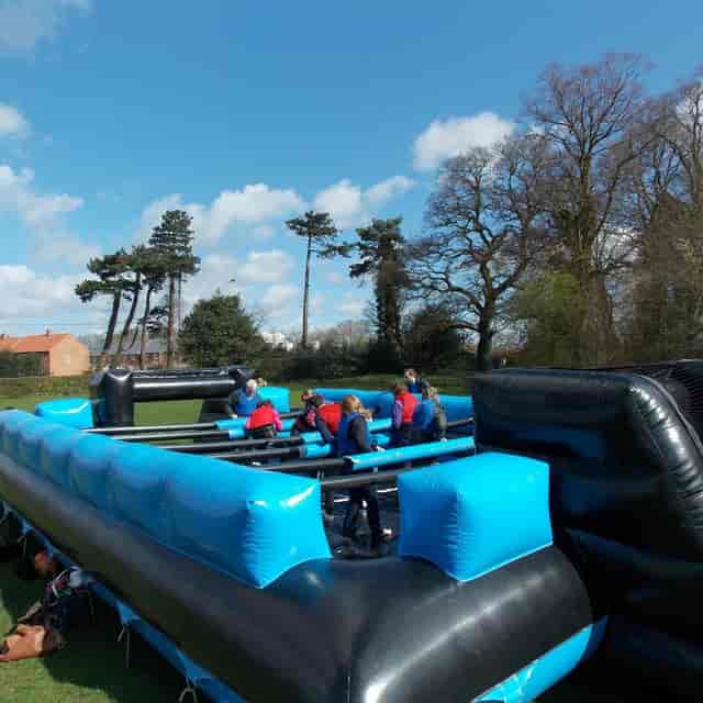 Inflatable human foosball arena for corporate team building and outdoor activity events.
