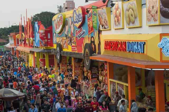 Jakarta Fair outdoor festival with crowded event activation and sponsor signage.