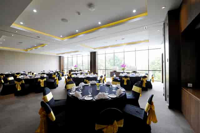 Sophisticated black-and-gold event hall with floor-to-ceiling windows for upscale gala dinners.