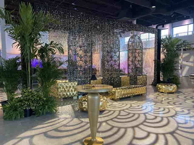 VIP lounge at Canvas Event Venue with gold tufted furniture and tropical decor for corporate events.