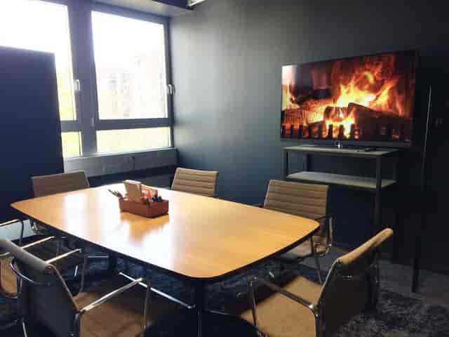 Modern Nextower meeting room with digital fireplace for hybrid corporate events.