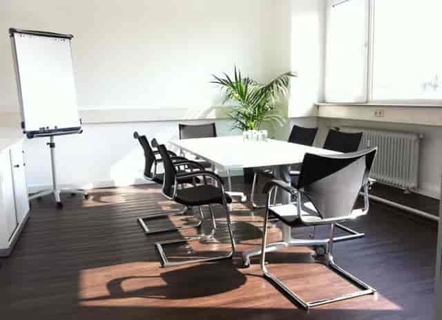 Boardroom meeting room at k1 BusinessClub Ostend with white table for productive corporate events.