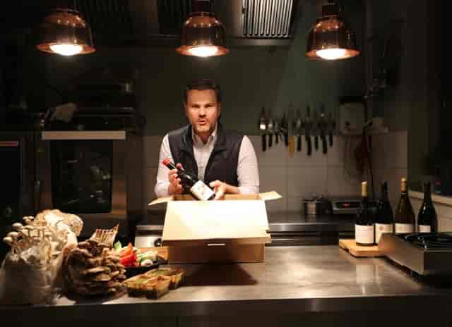 Professional chef in Frankfurt kitchen for virtual culinary and wine tasting events.