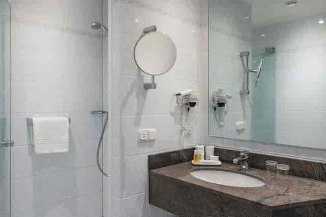 Boardroom bathroom at Crowne Plaza Frankfurt: modern glass shower, ideal for corporate event lodging.