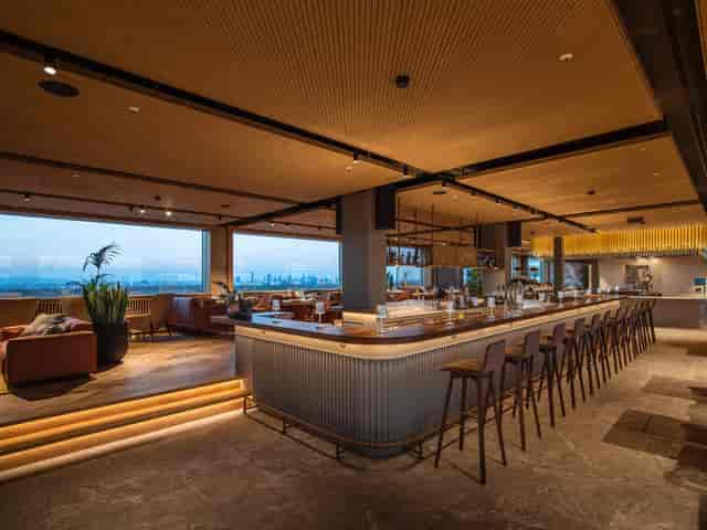 Rooftop restaurant with skyline windows for corporate events and networking mixers.