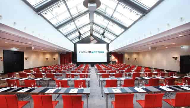 Classroom-style meeting room at Lindner Hotel Frankfurt with glass atrium for corporate training.