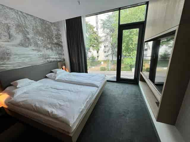 Modern hotel room with split-king bed for business travel and corporate event room blocks.