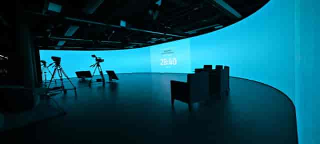 Hybrid broadcast studio at Spark Frankfurt with curved LED backdrop for professional panel events.
