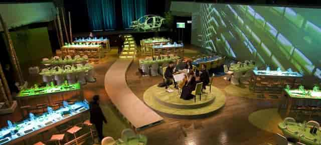 Corporate gala event at Zoo Gesellschaftshaus featuring an automotive centerpiece and stage.