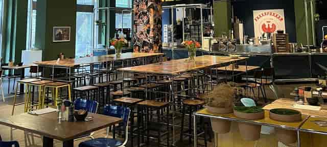 Industrial-chic bar at NEUE KAISER with communal tables for networking and workshop events.