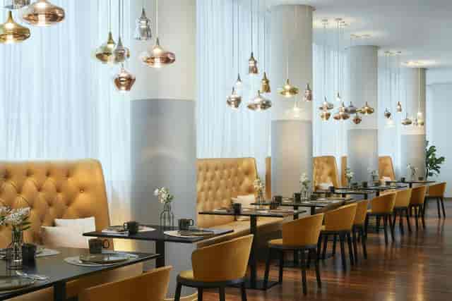 VIP lounge with tufted banquette seating for corporate events and networking breakouts.