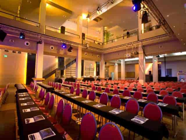 Classroom-style conference in Halle 3 with AV rigging for corporate plenary events.