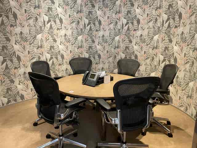 Small meeting room with round table for corporate team collaboration and breakout sessions.