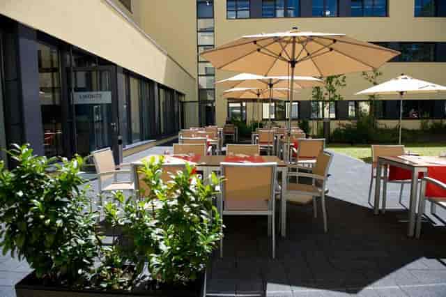 Outdoor networking breakout session at Bronze, Lindner Hotel Frankfurt, featuring shaded seating.