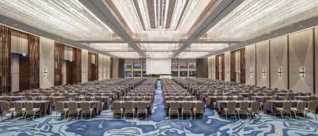 Hilton ballroom configured for a large-scale classroom plenary event with professional AV setup.