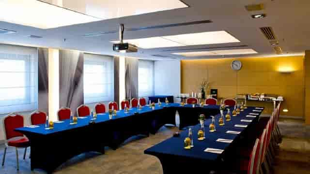 U-shaped meeting room in Divan with blue linens for business presentations and corporate events.