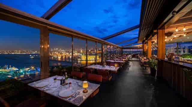 Rooftop meeting room with glass walls and city views for corporate dinners and event receptions.