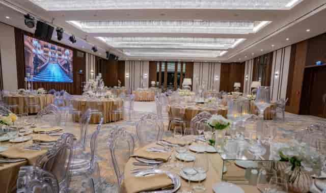 Crowne Plaza Istanbul ballroom with ghost chairs and gold linens for corporate and social events.