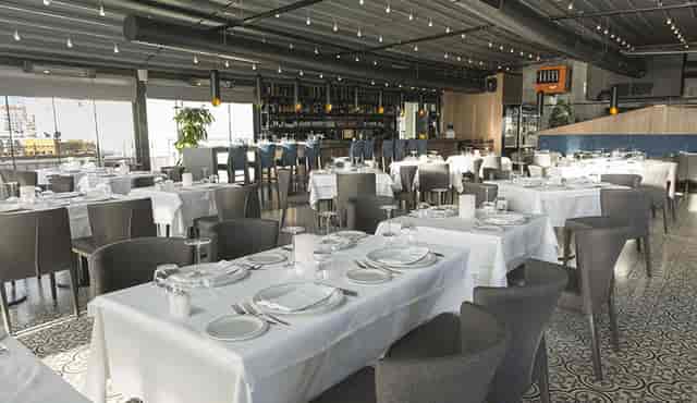 Modern Ouzo Roof banquet space with industrial decor for corporate luncheons and social dinners.