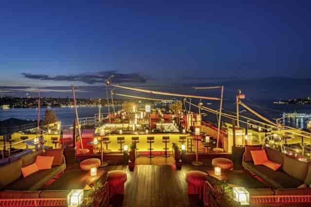 Rooftop restaurant with tiered lounge seating for corporate networking and evening reception events.