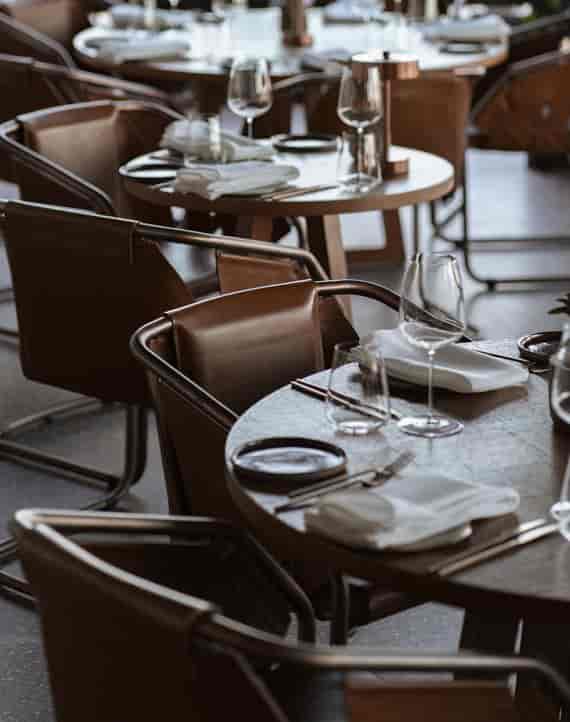 Minimalist Serica Restaurant dining room with leather chairs for corporate dinners or boutique events.